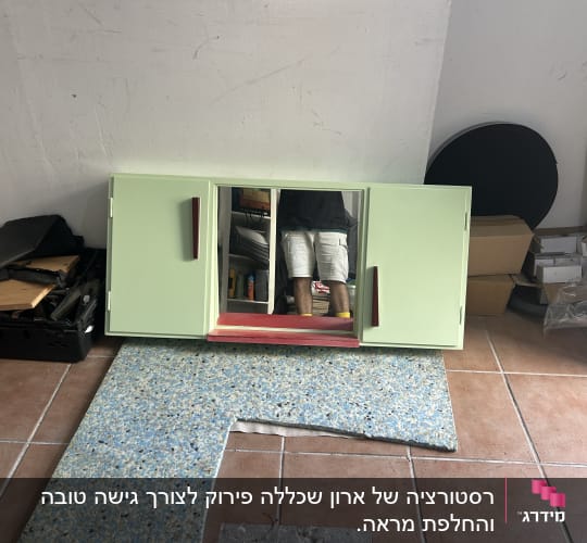 ארון ירוק עם מראה וכלים על רצפת אריחים